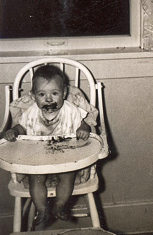 A messy baby from the late 1940s, in her high chair.